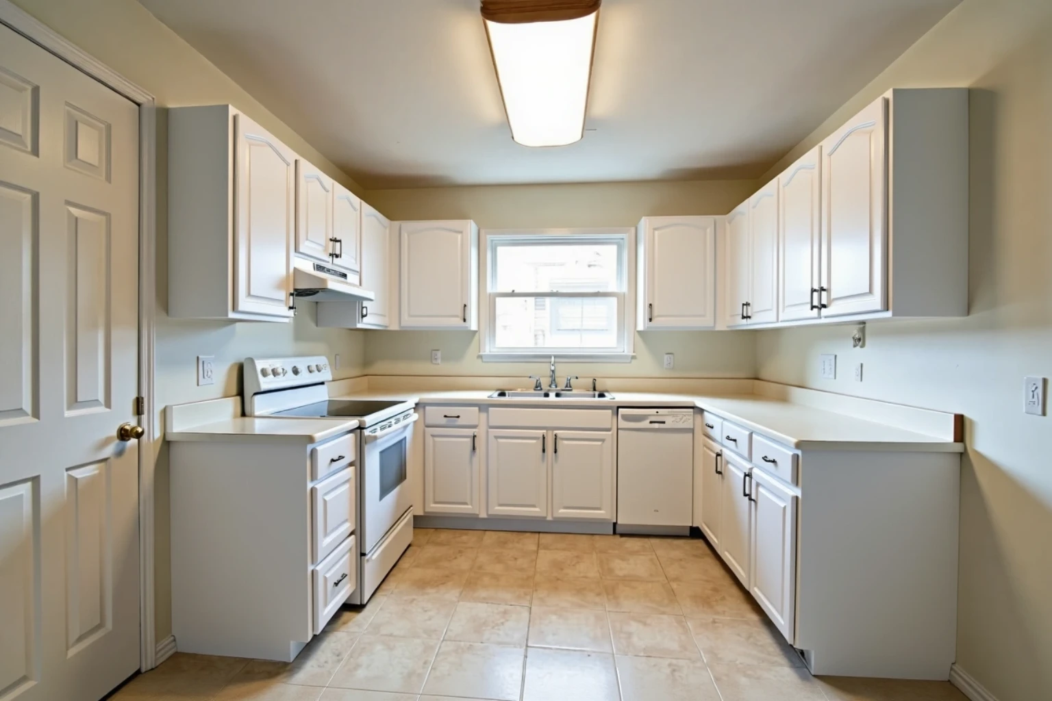 The same kitchen with every door and drawer front now white with black bar pulls, counters and appliances unchanged.